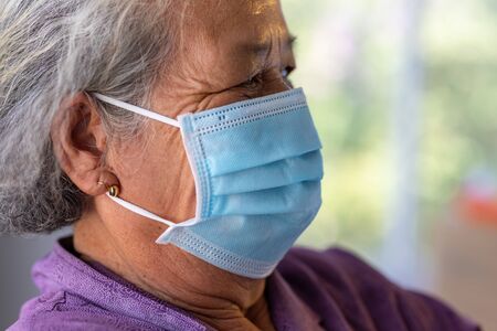 Senior asian woman wearing face mask during corona virus and flu outbreak. Disease and illness protection. the aging female patient that is at risk for infection corona virus [covid-19].の写真素材