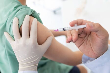 Close up of a Doctor making a vaccination in the shoulder of patient, Flu Vaccination Injection on...