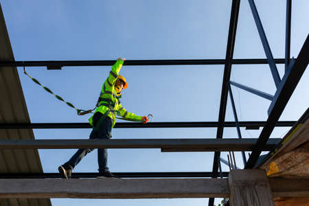 Asian worker wear safety height equipment to install the roof in the construction site;. Fall...