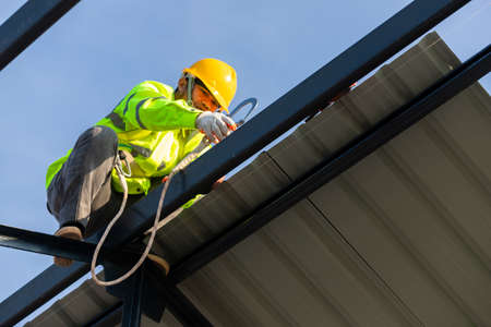 Asian roof construction worker wear safety height equipment to install the roof frame, Fall arrestor...