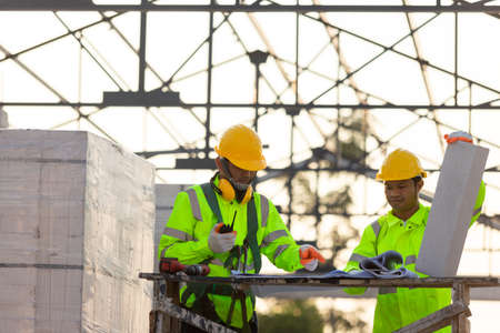 Asian engineers and consultant workers calculate the amount of bricks used in construction, Concept of construction team work.の写真素材