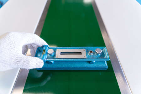 Close up of hand Mechanic technician worker use a water level meter working and Assemble the product sorting machine conveyer in industrial factory.の写真素材