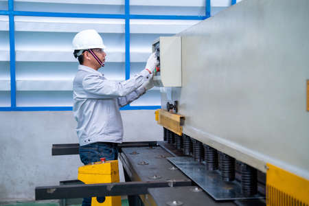 Asian worker wearing a safety suit and setting Hydraulic Press Break Machine and Prepared Sheet...