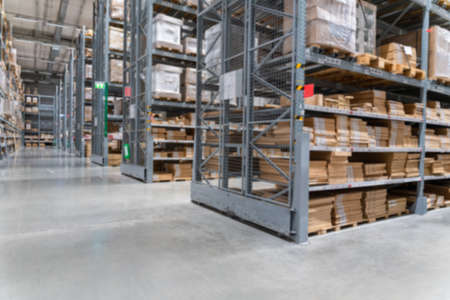 blurred background image of Rows of shelves with goods boxes in modern industry warehouse store at factory warehouse storageの写真素材