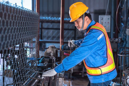 Asian technician worker working contone production machine  steel wire mesh for construction work in...