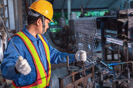 Asian technician worker working contone production machine  steel wire mesh for construction work in...