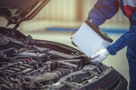 Close up hand technician or auto mechanic change the car battery in auto repair car service center.の写真素材