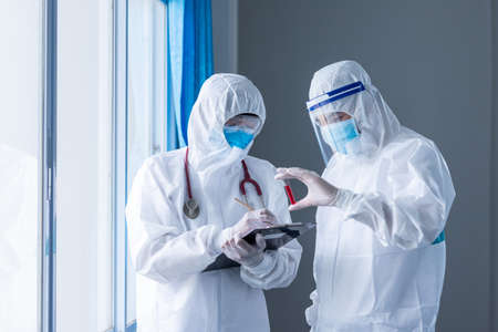 Two doctor holding blood sample test tube on white background. concept of Coronavirus or COVID-19 outbreak, Concept of finding ways to prevent the spread of coronavirus.の写真素材