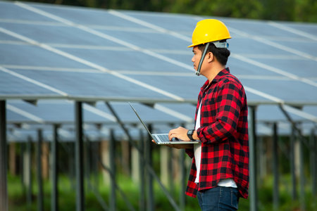 Asian engineer working on checking equipment and use a laptop to measure the heat temperature in solar power plant.の写真素材