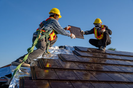 Team work construction worker install new ceramic tile roof with Roofing tools electric drill used in the construction site.の写真素材