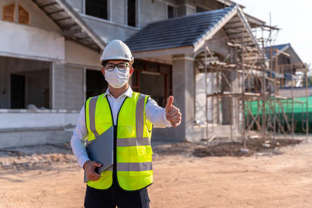 Portrait of Architect wearing a mask on a building construction site, Homebuilding Ideas and Prevention of  Disease.の写真素材