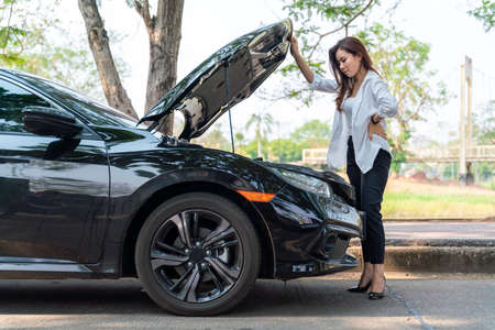 Asian business woman she opened the hood Broken car on the side See engines that are damaged or not.の写真素材