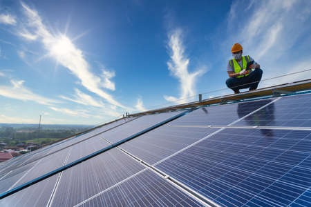 Asian technician checking the maintenance of the solar panels on roof, solar energyの写真素材