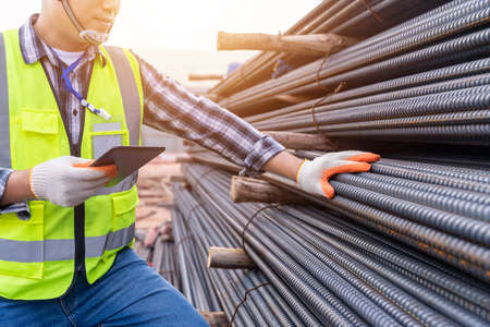 Close up of Construction engineer or worker use a tablet checking quality steel for concrete...