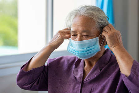 close-up portrait of asian senior woman wear a mask to prevent the spread of coronavirus or COVID-19 disease, Old thai womanの写真素材
