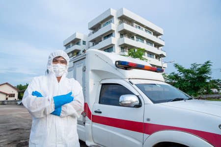 doctor nurse staff wear PPE in front of the ambulance with protective suit, mask gloves at ambulance car vehicle for helping the patient of Coronavirus or Covid-19 at Hospital backgroundの写真素材