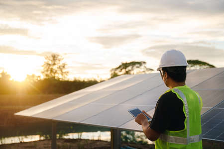 The solar farm or solar panel with Solar cell engineer using a tablet check and maintenance equipment at industry solar power, Photovoltaic module idea for clean energy production.の写真素材
