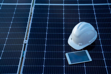 Top view of helmet with tablet on the solar panel for working solar station photovoltaic panels,...
