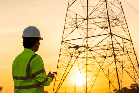 Engineers or Electrician use drone to fly inspections at the electric power station to view the...