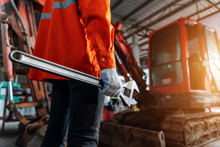 Close up of a human hand holding a tool for maintenance or excavator at maintenance center, Heavy Duty Equipment Maintenance. Industrial Concept.の写真素材