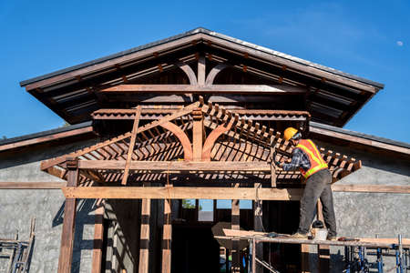 Carpenter working on roof structure on construction siteの写真素材