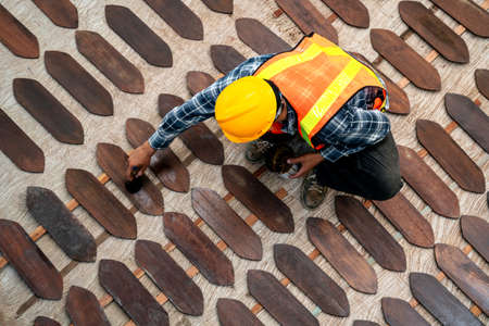 Top view of worker painting or varnish on wooden board on construction site.の写真素材