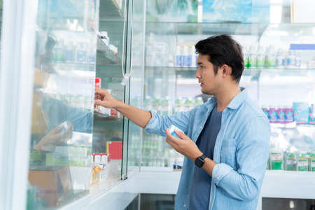 A man is buying medicines to treat his condition in a pharmacy, Medical healthcare concept.の写真素材