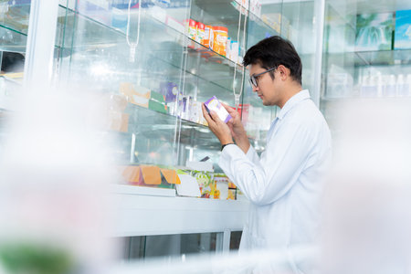 A male pharmacist holding prescription checking medicine in pharmacy or drugstore, Medical healthcare concept.の写真素材