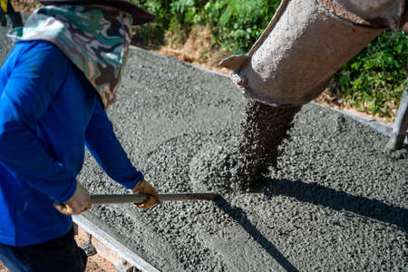 Concrete pouring during commercial concreting floors at road construction site, Civil Engineerの写真素材