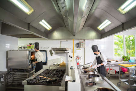 Asian two chefs prepare meals in the restaurant's kitchen. Modern kitchen.の写真素材