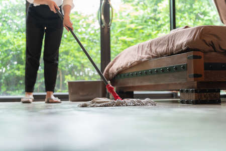 housewife using a mop in hotel room.の写真素材