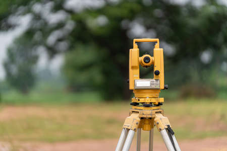 Back of Surveyors equipment (theodolite or total positioning station) on the construction site of the road or building with construction machinery backgroundの写真素材