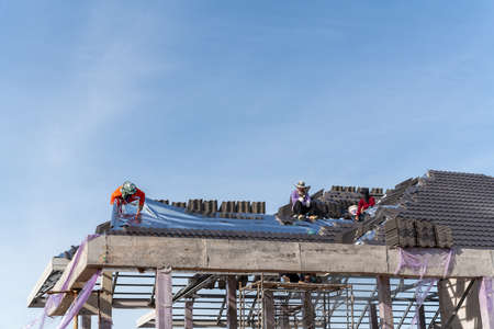 Roofers is installing insulating sheets on a concrete tile roof.の写真素材