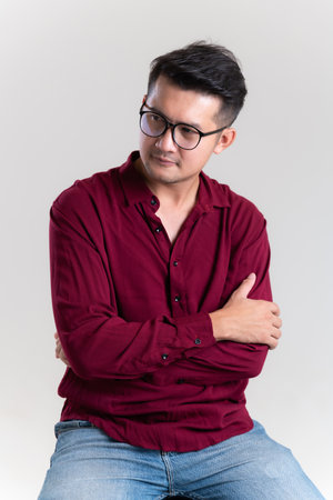 Portrait of Handsome young asian man posing on grey background. dressed casually with happy and self-confident positive expression with crossed arms. Concept good attitude of adult.の写真素材