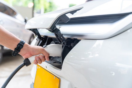 Human hand charging electric car battery at home. Electric car charging station. Concept of green energy and reduce CO2 emission. EV car.の写真素材