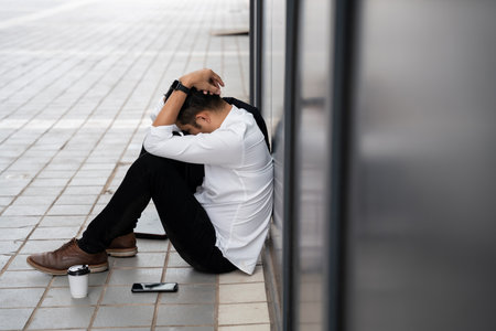 Asian man or People unemployed businessman stress sitting in urban public spaces. concept of business failure and unemployment problem.の写真素材