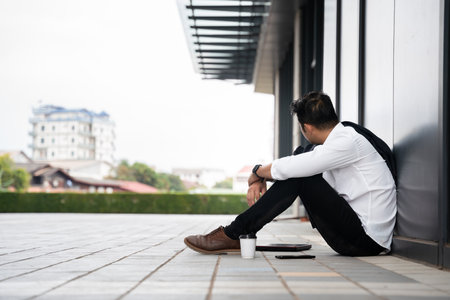 A man or People unemployed businessman stress sitting in urban public spaces. concept of business failure and unemployment problem.の写真素材