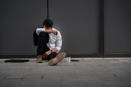 Asian man or People unemployed businessman stress sitting in urban public spaces. concept of business failure and unemployment problem. Despair low economic crisis.の写真素材