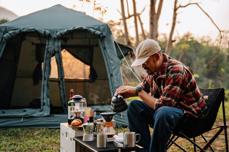 Asian camper, A man drip coffee in the camp, A man pouring water on coffee ground with filter.Drip coffee and camping.の写真素材