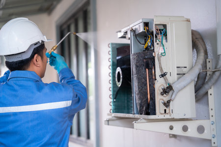 Air conditioner technician is using a high-pressure water jet to clean the air conditioner. Service concept of an air conditioner technician.の写真素材
