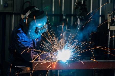 A Workers are welding steel at a heavy industry factory. Industrial safety first concept.の写真素材