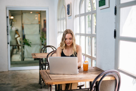 A Freelancer woman using a laptop sitting at a table. freelance concept.の写真素材