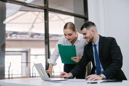 A businessman with co-worker female with touch screen Sales planning, research or financial strategy in company, collaboration concept, technology and workers.の写真素材