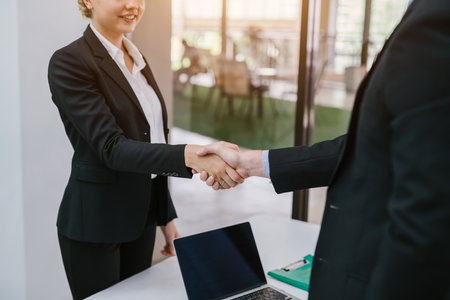 Two Businesspeople shaking hands indoors. Concept of successful business people shaking hands.の写真素材