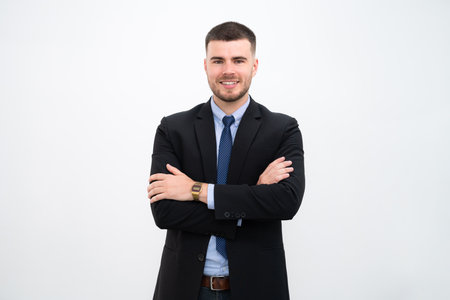 A businessman wearing a suit with his arms crossed on white backgroundの写真素材