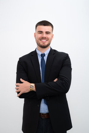 A businessman wearing a suit and Smiling young handsome caucasian man his arms crossed on white background.の写真素材