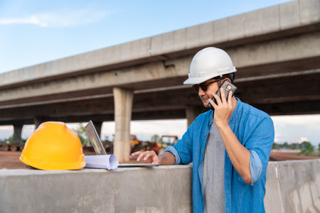 Asian Civil engineer work at road construction sites to supervise new road construction and inspect...