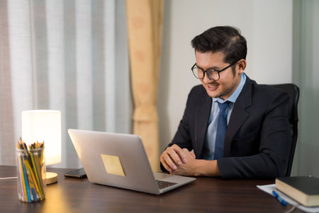 A businessman having online meeting with laptop in private office.の写真素材