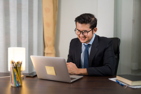 Asian businessman having online meeting with laptop from home.の写真素材