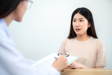 Asian female client or patient giving thanks to female doctor at ball hospital after getting treatment and medical advice.の写真素材